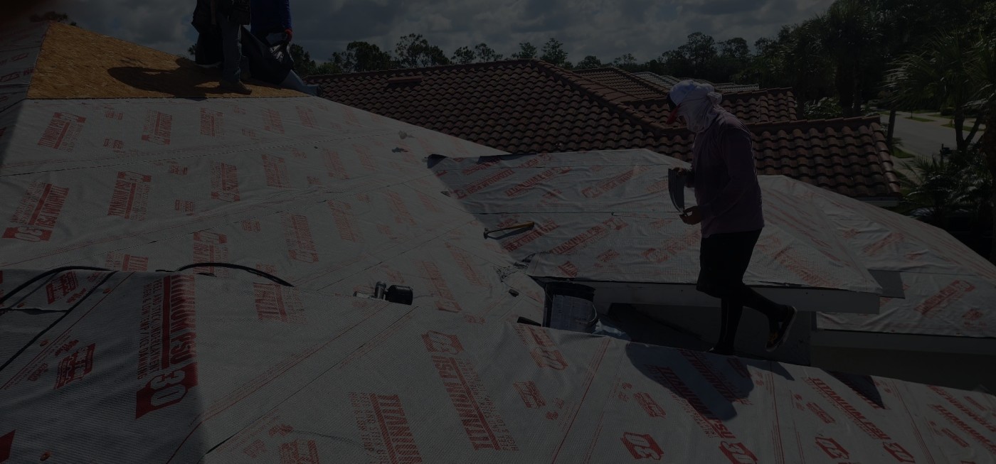 Roofer installing underlayment on residential project